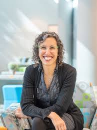 candidate photo of woman smiling in camera, arms crossed.